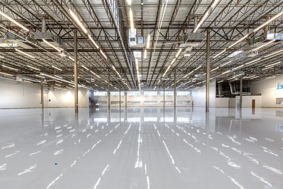 A large commercial facility with a finished high-gloss floor reflecting rows of overhead lights